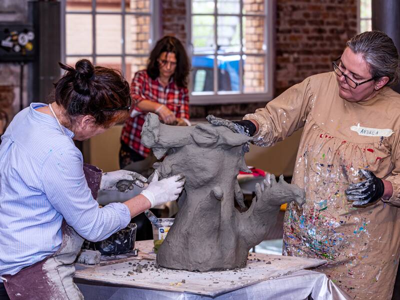 Drei Frauen arbeiten an Skulpturen in der Szene 64
